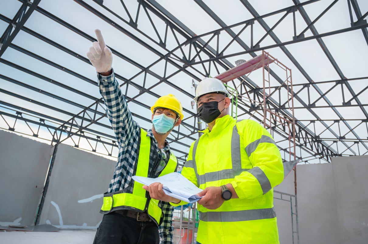 Civil engineer inspect structure at construction site against blueprint, Building inspectors jointly inspect the building structure with civil engineer. Civil engineer hold blueprint inspect building.